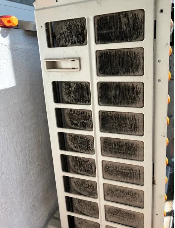 Grille et filtre de climatisation saturés d'encrassement avant nettoyage