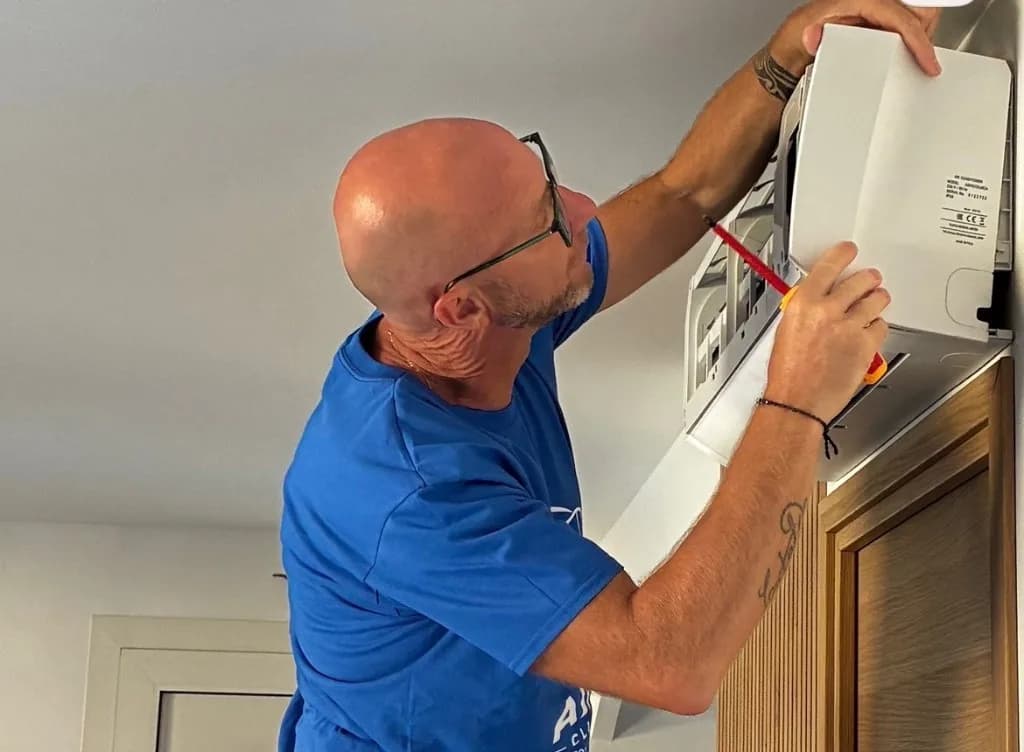Technicien Air Net Climatisation en intervention sur une climatisation murale